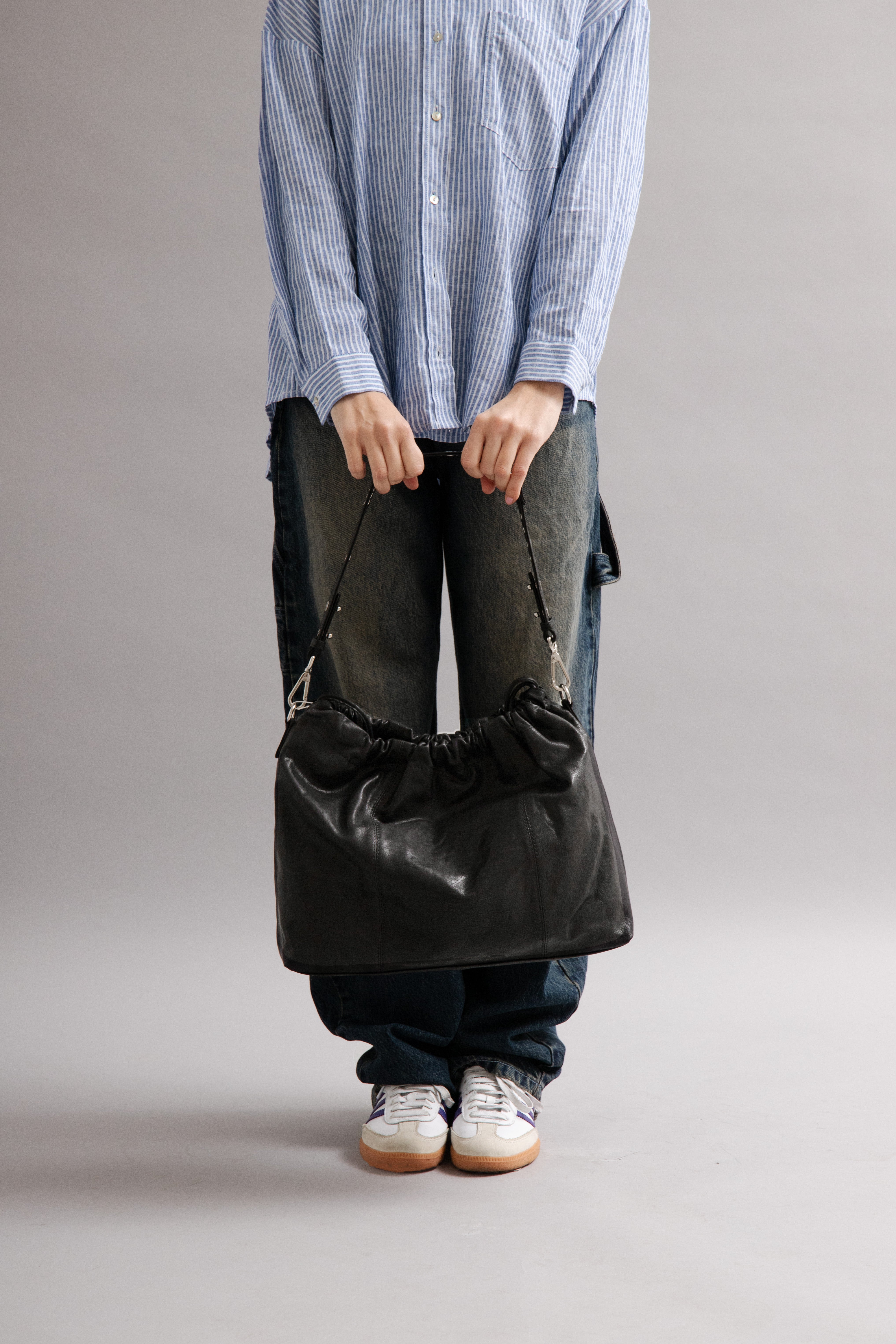 Girl wearing Elliot Black leather shoulder and crossbody bag of the brand Neuville in the studio