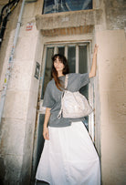 Model wearing Elliot Sand gold Shoulderbag and crossbody bag of the brand Neuville.