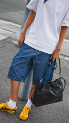 Girl wearing Elliot Black leather shoulder -  crossbody bag of the brand Neuville in the street