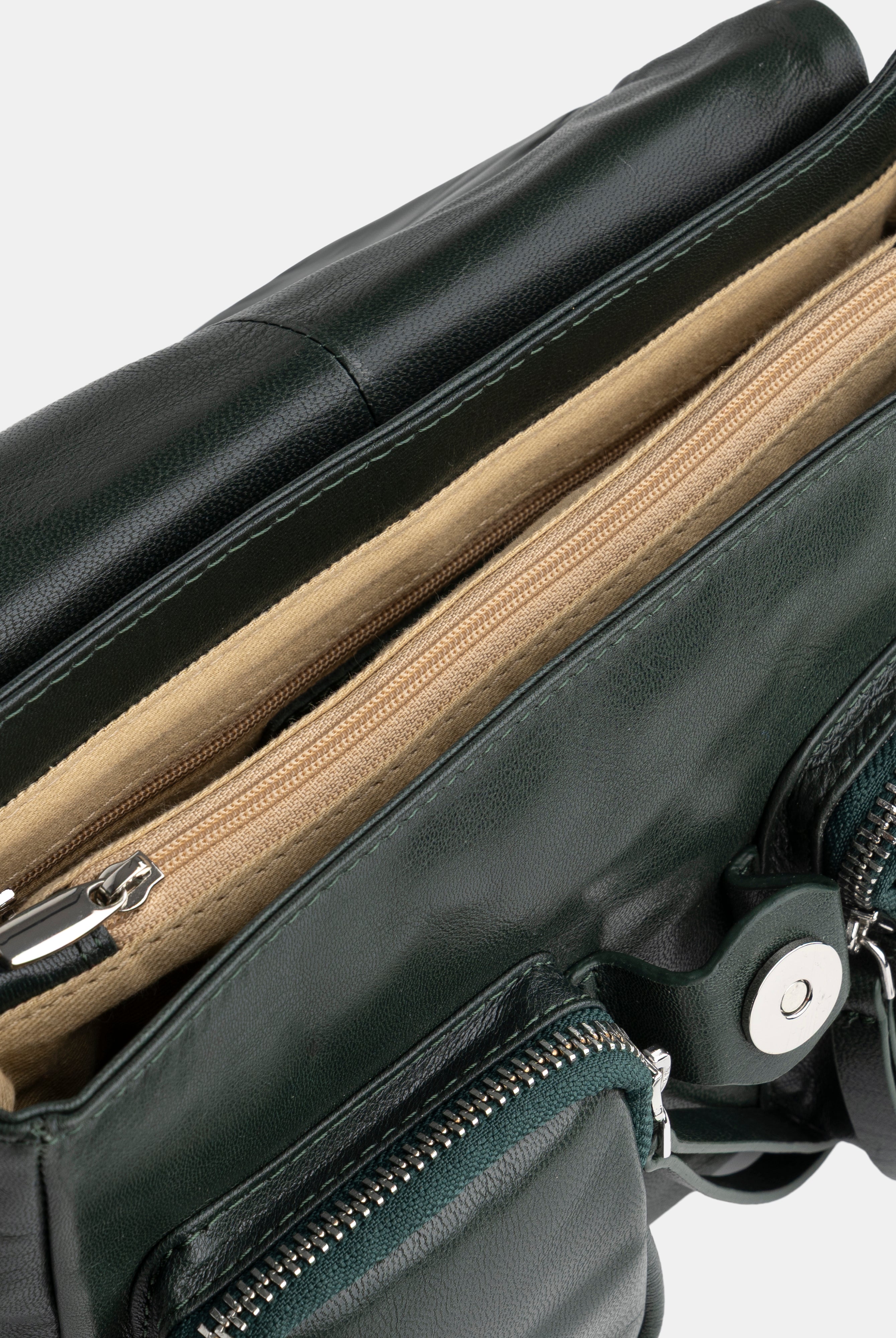 Green leather bag with zippers on a white background