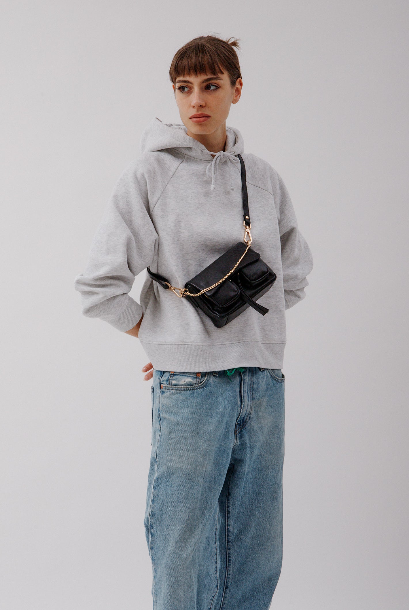 Max Mini Black with golden hardware on model worn as a corssbody bag