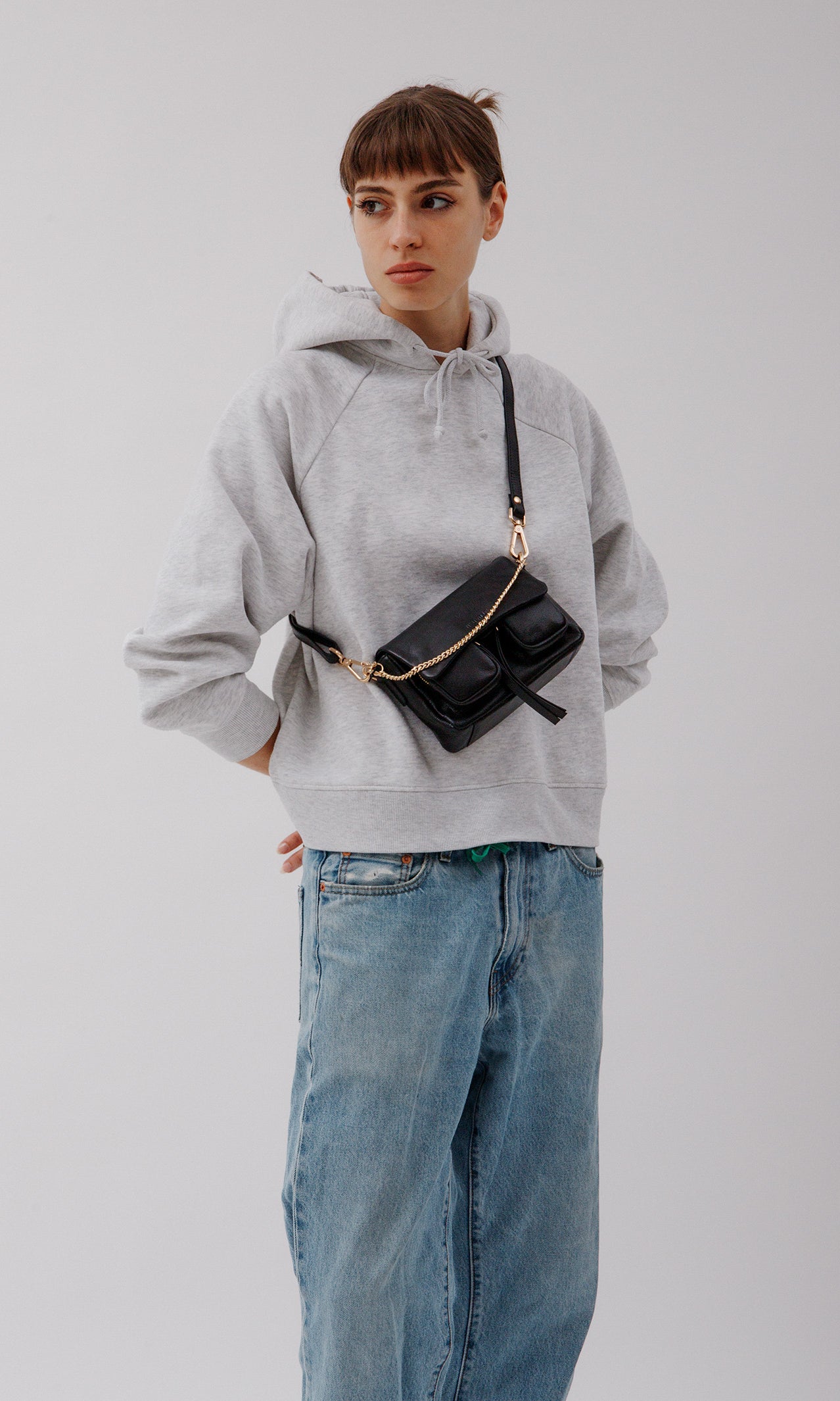 Max Mini Black with golden hardware on model worn as a corssbody bag