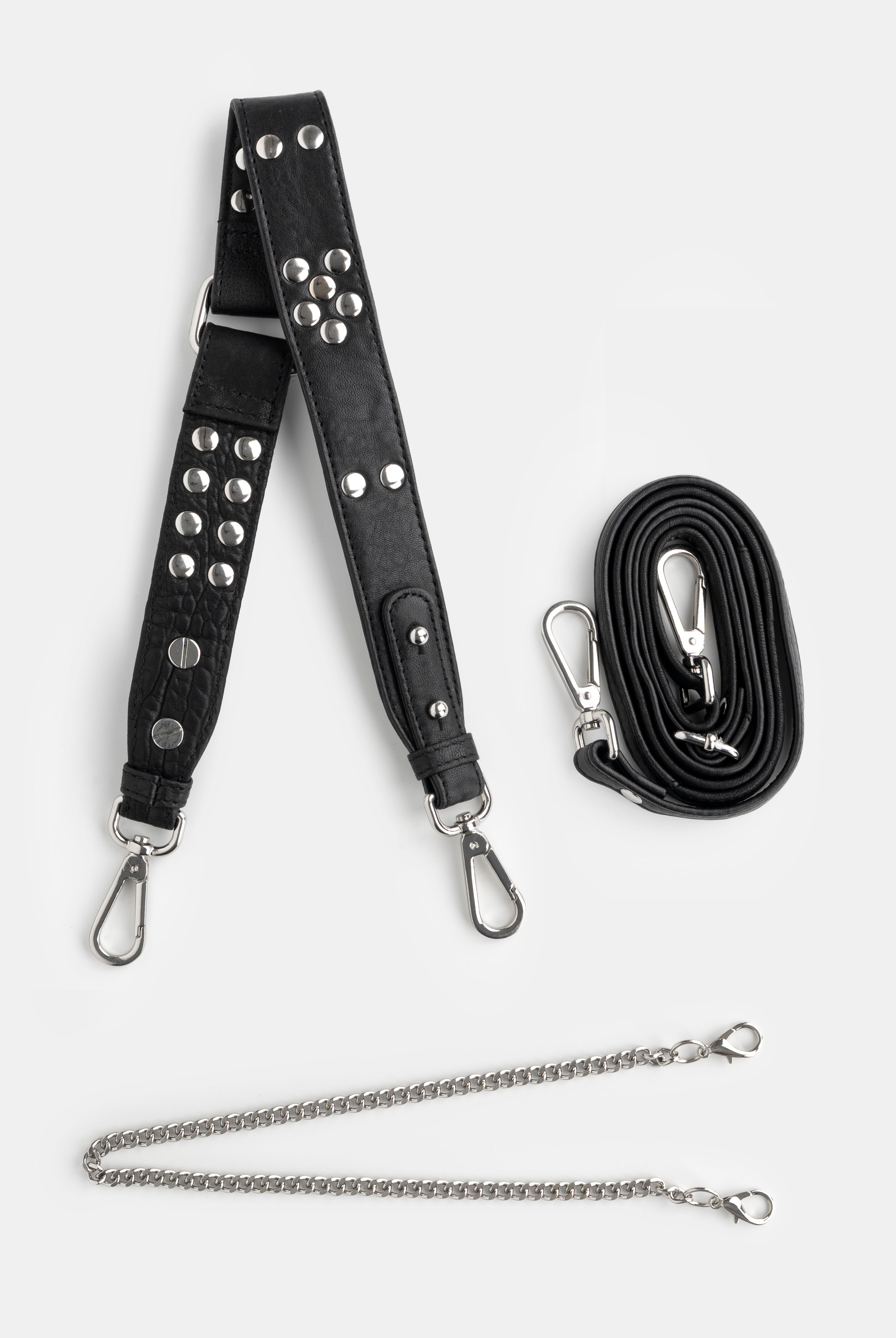 Black studded bag strap with silver hardware and a chain extension on a white background