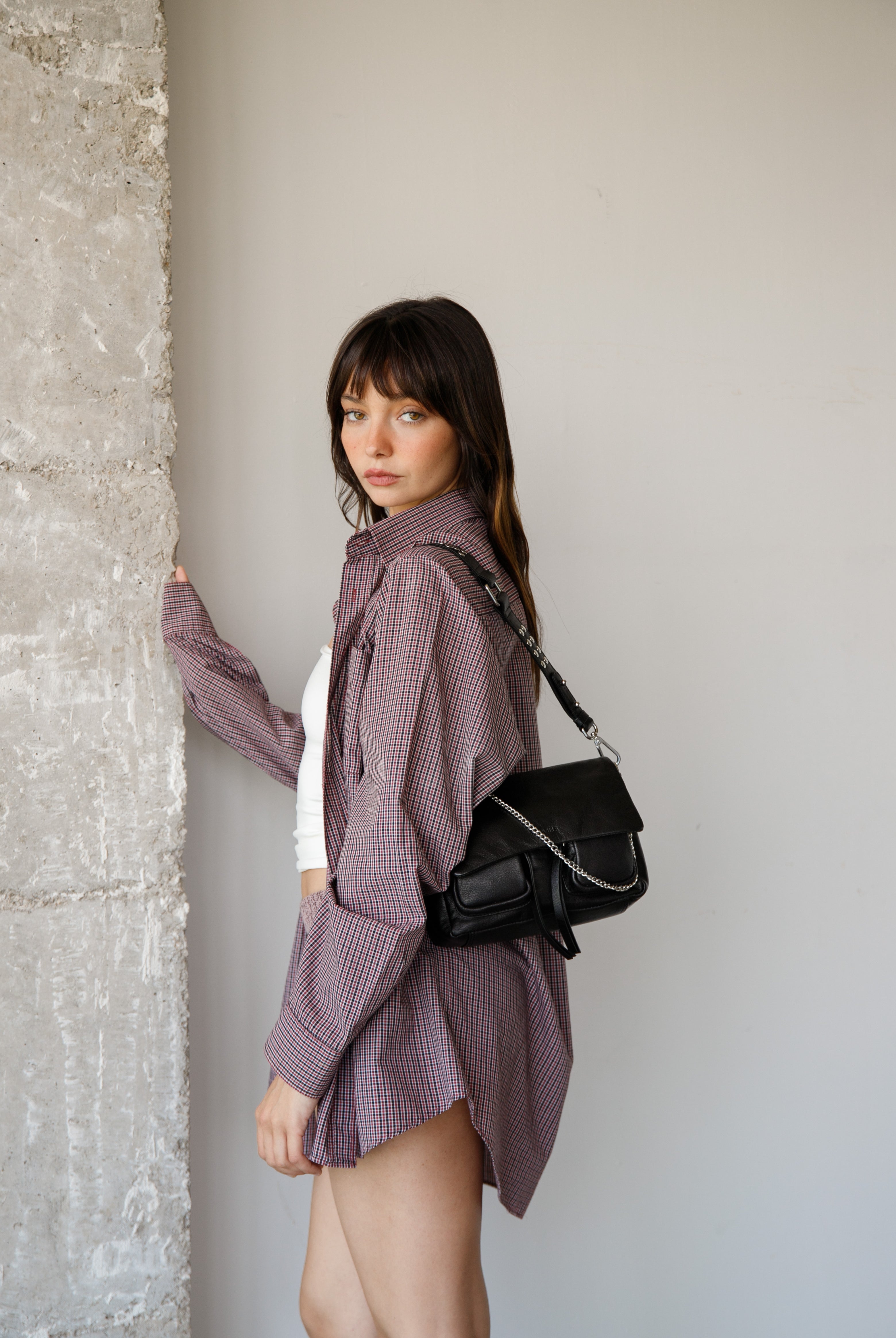 Maxke Black Leather shoulderbag with chain worn by a woman. Neuville bag