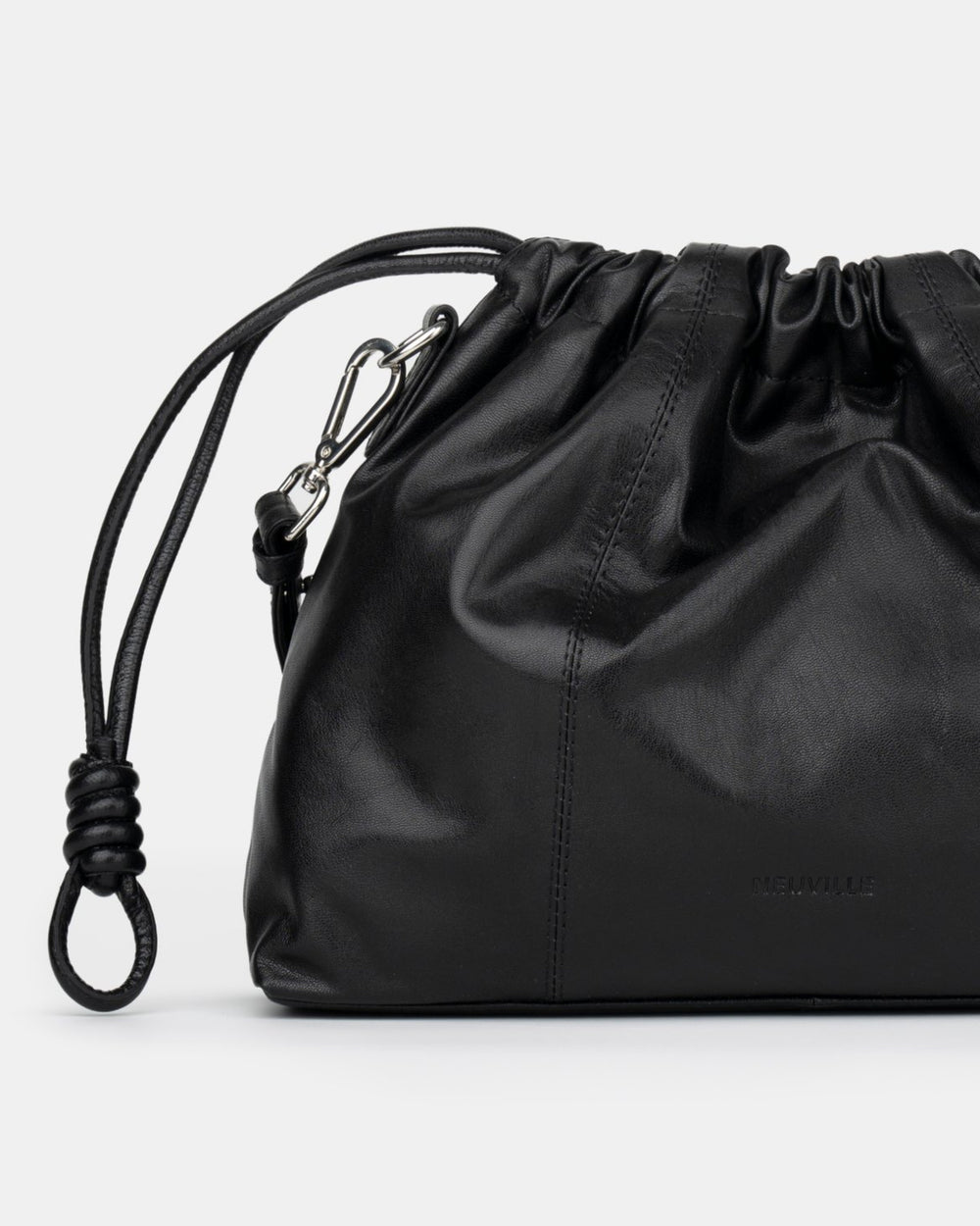 Le même cuir souple et froncé que l'Elliot, en plus petit, avec deux cordons qui ajustent la forme et ferment le sac d'un seul geste.
