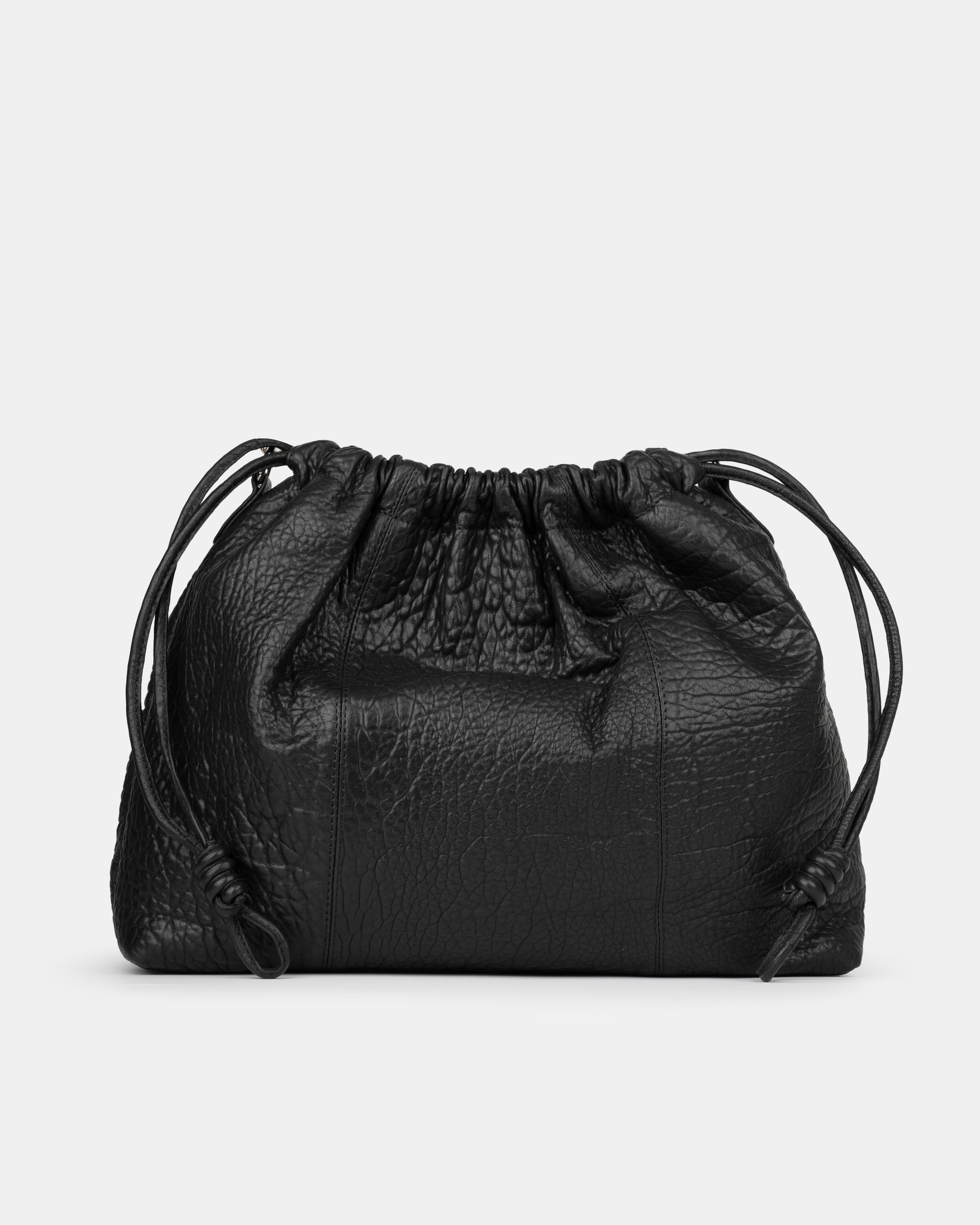 Black leather drawstring bag on a light gray background - back photo