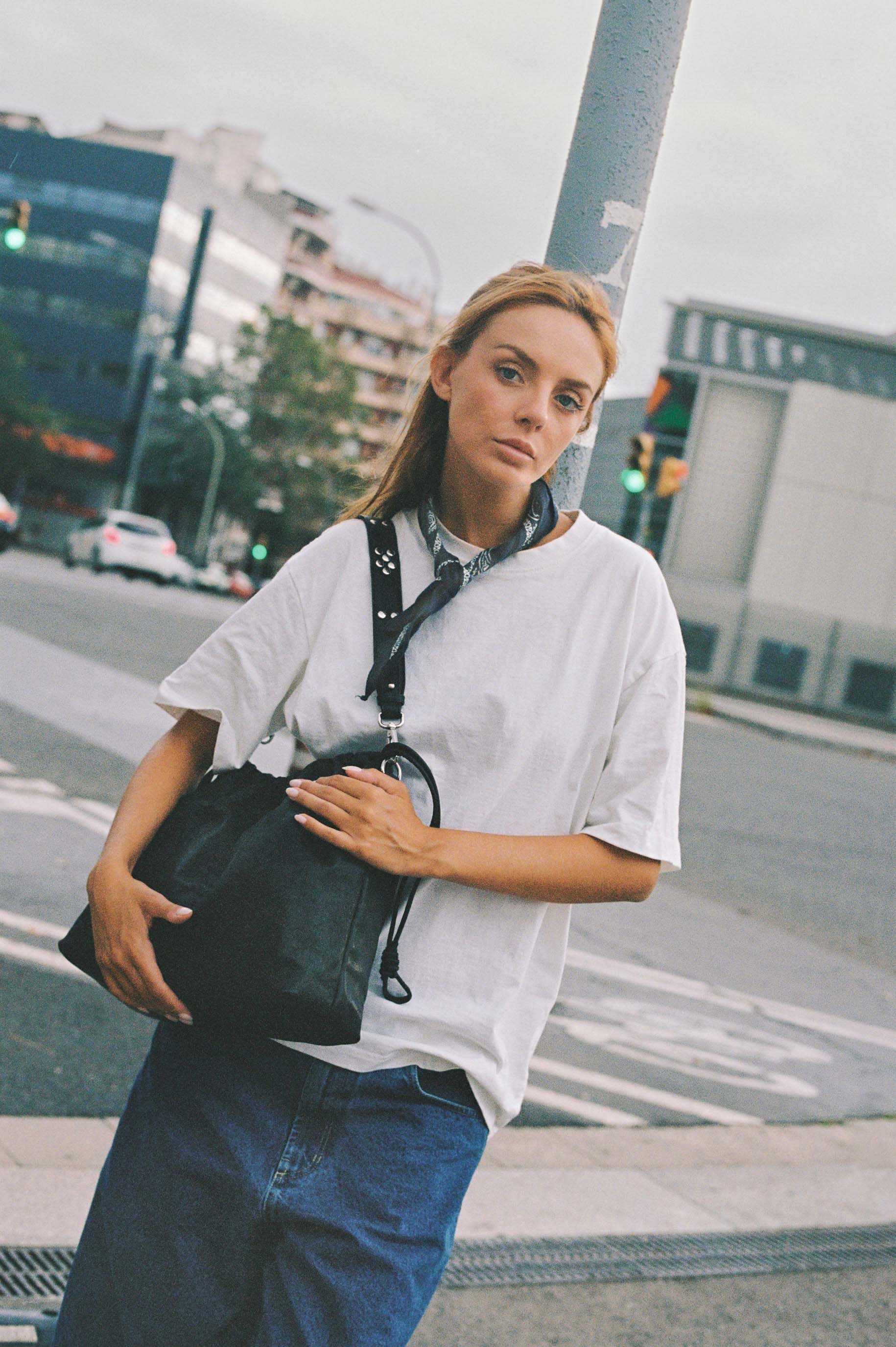 Girl wearing Elliot Black leather shoulder and crossbody bag of the brand Neuville in the street