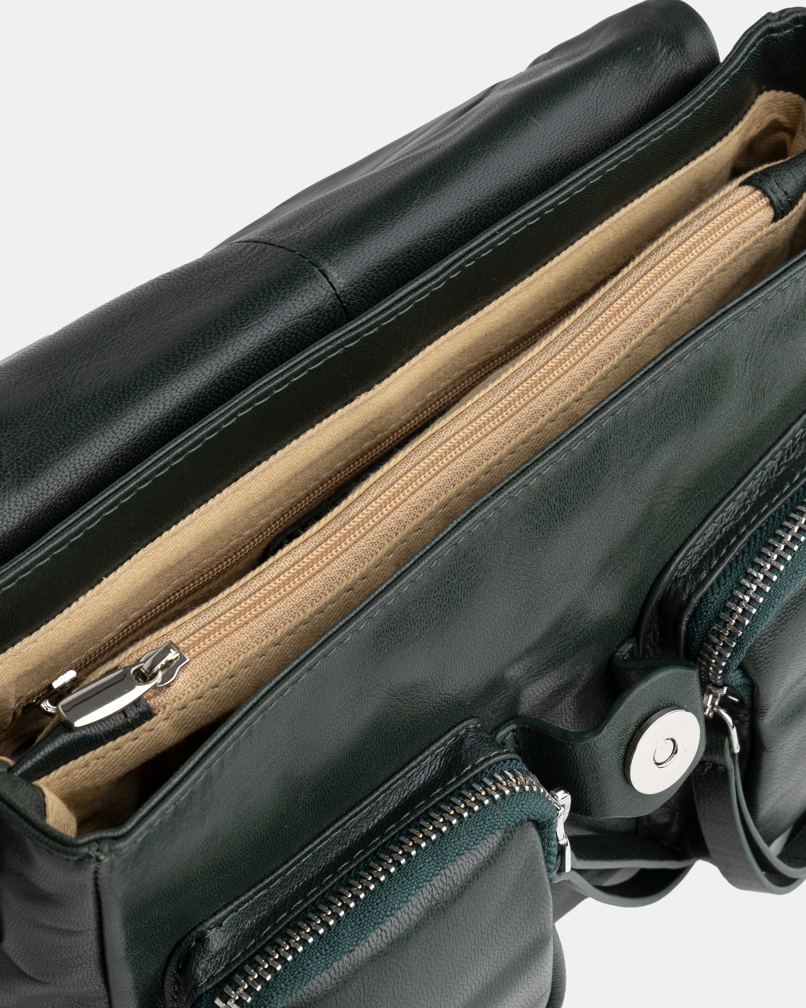 Green leather bag with zippers on a white background