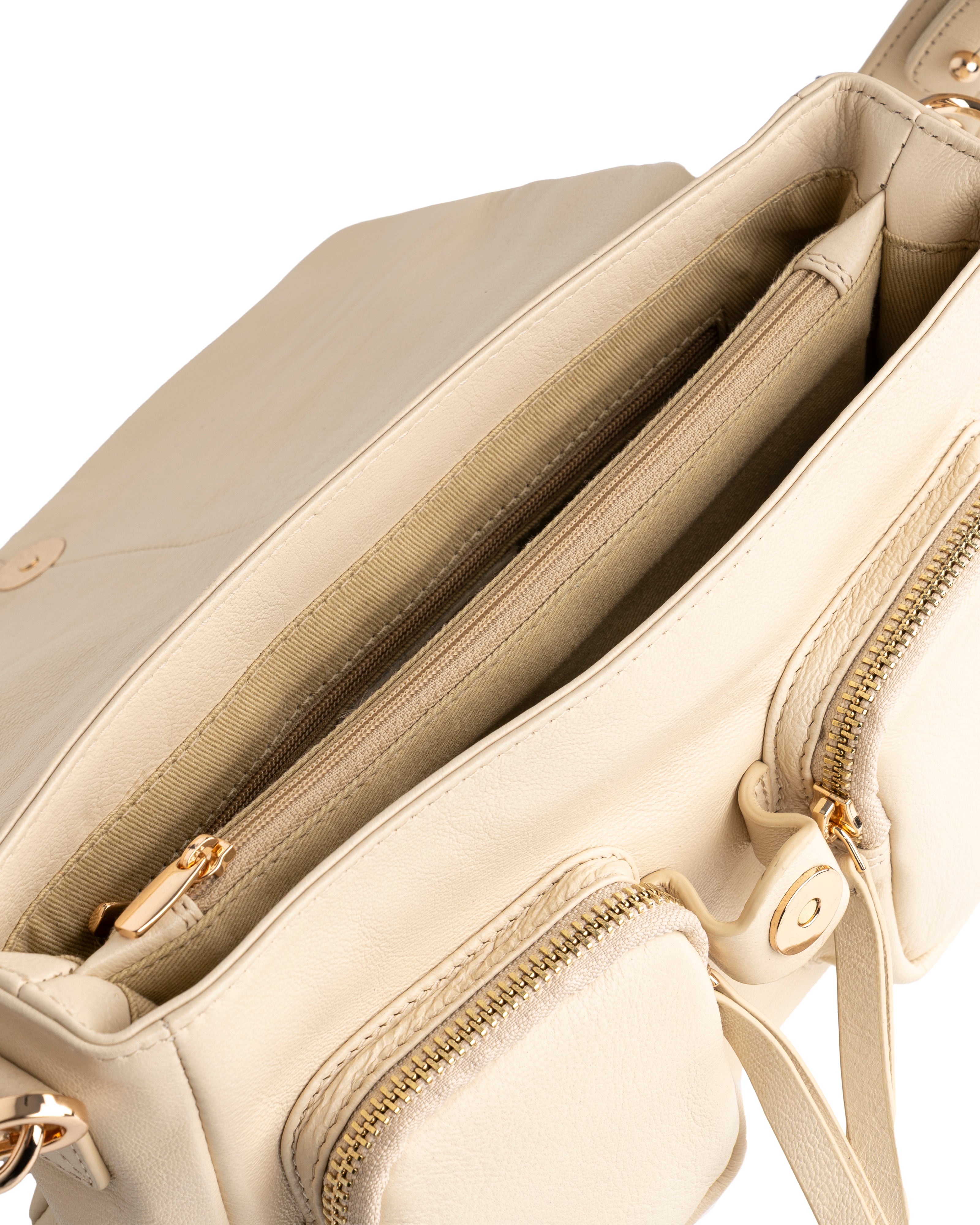 Close-up of a beige handbag with gold zippers and hardware.