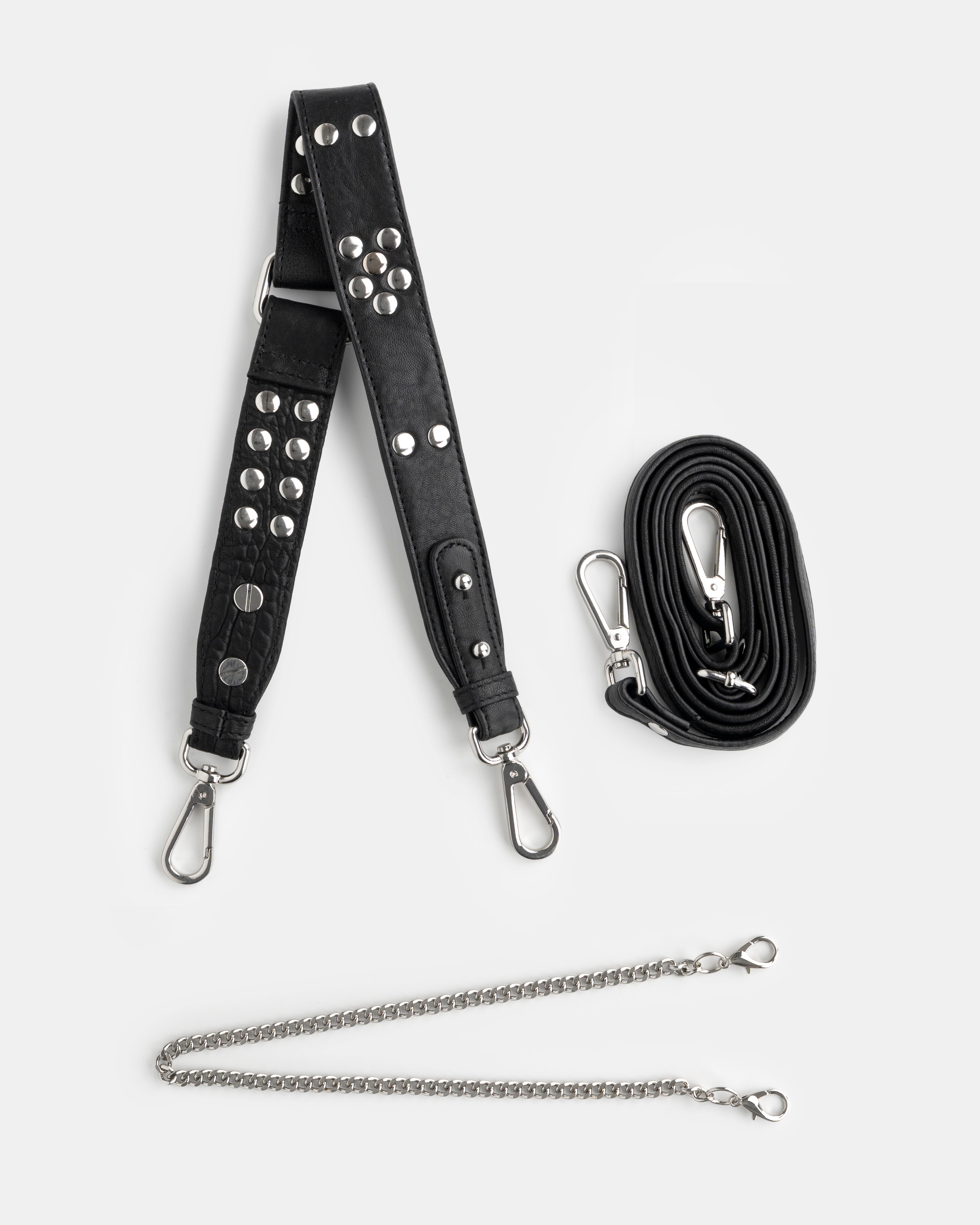 Black studded bag strap with silver hardware and a chain extension on a white background