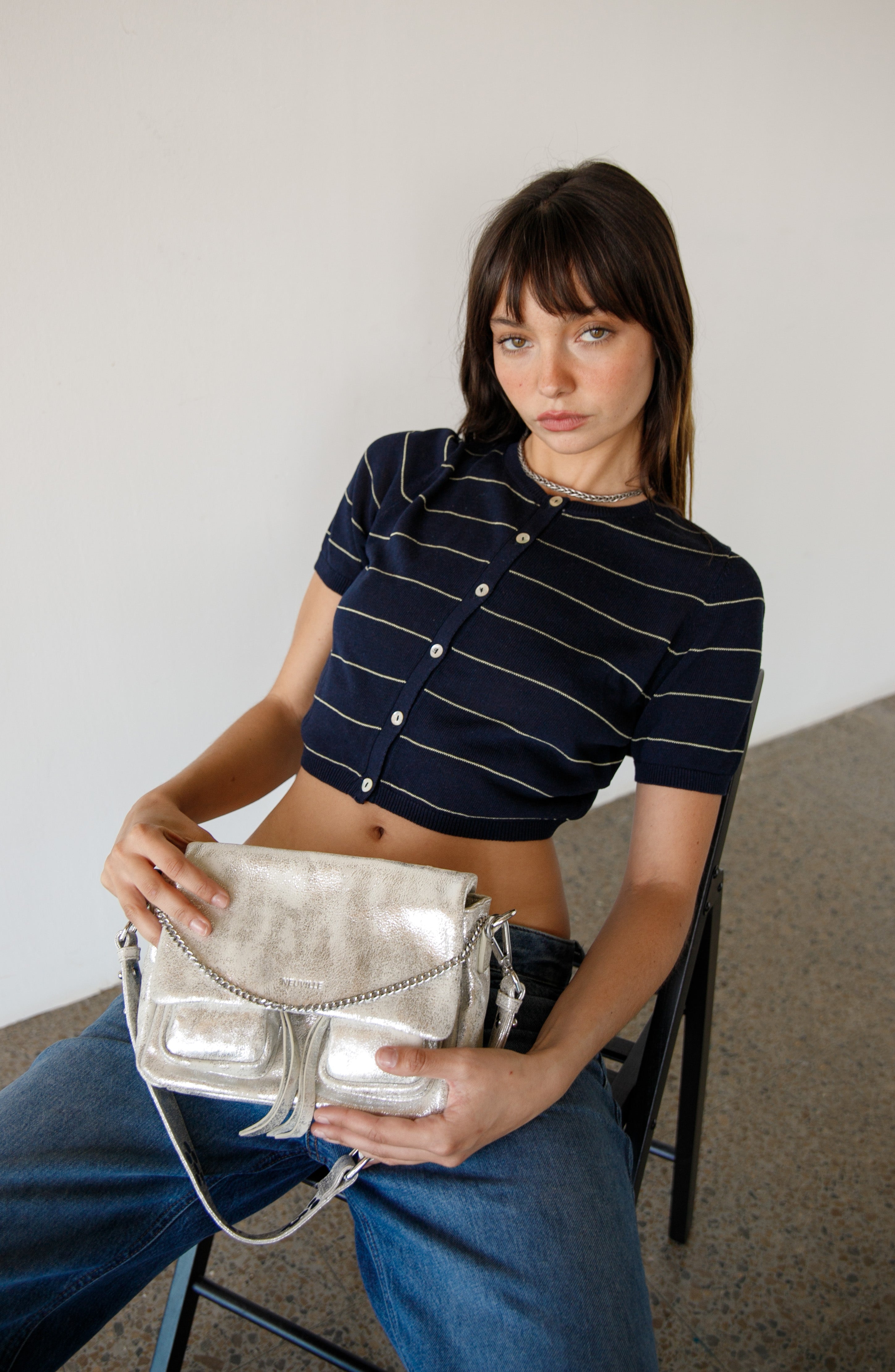 Woman holding Maxke sand gold handbag  of the brand Neuville